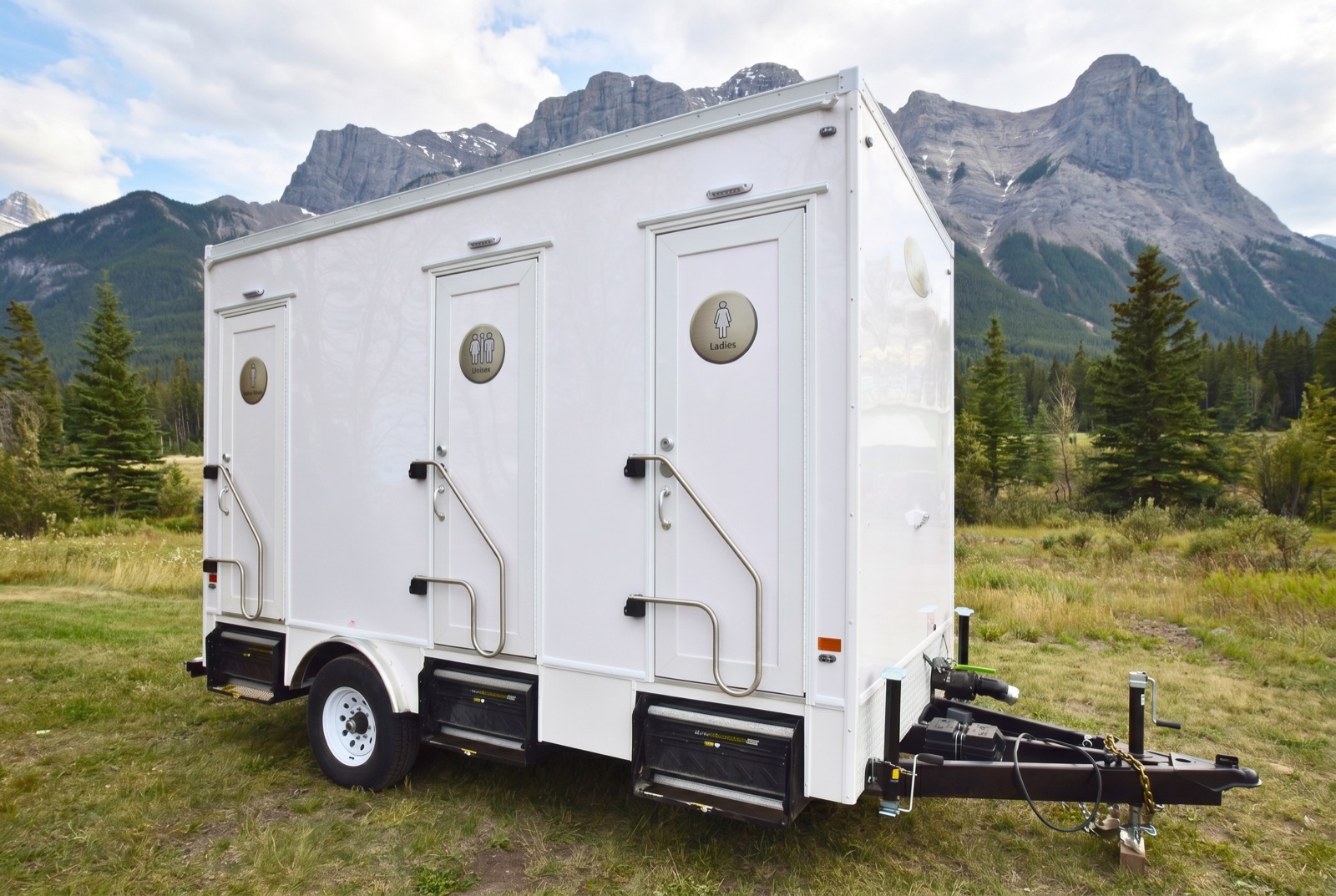 Washroom trailer with the Rocky Mountains behind it near Canmore